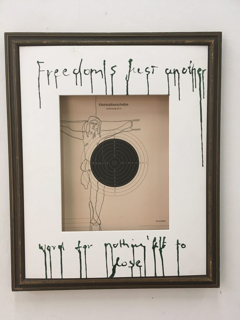 Zeichnung auf Kleinkaliberscheibe, gerahmt, beschriftet mit "Freedom is just another word for nothing left to lose"